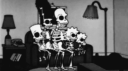 The Simpsons family, as skeletons, pile onto their couch in a classic 'couch gag'